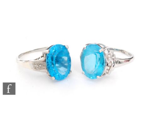A 14ct white gold paste electric blue stone and diamond ring, central oval stone with diamond set shoulders, weight 6.6g, wit