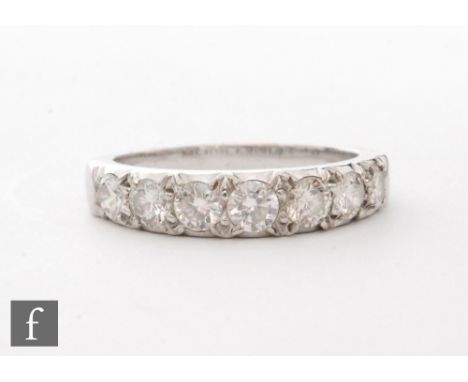 An 18ct white gold diamond seven stone half eternity ring, claw set brilliant cut stones, total stone weight approximately 1.