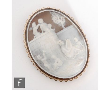 A modern 9ct hallmarked mounted oval cameo brooch depicting a maiden playing a lyre with cherubs in attendance to a garden se