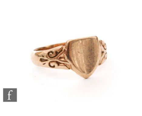 An early 20th Century 9ct rose gold child's ring with vacant shield flanked by scroll detailed shoulders, weight 1.3g, Birmin