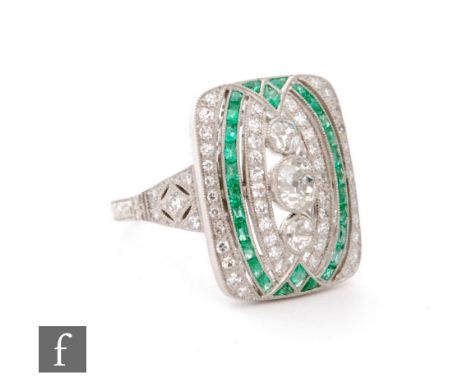 A platinum Art Deco style emerald and diamond cluster ring, three vertically set diamonds within an alternating emerald and d