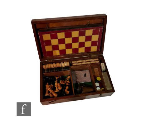 An early 20th Century mahogany inlaid games compendium with a harlequin assortment of playing pieces, the hinged cover reveal