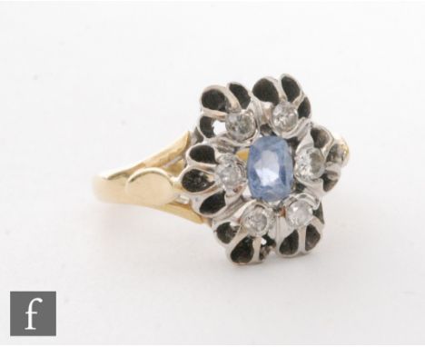 An 18ct sapphire and diamond cluster ring, central oval sapphire with a six stone diamond surround, ring size J. 