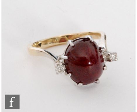 An 18ct ruby and diamond three stone ring, central cabachon cut ruby flanked by a brilliant cut diamond to either side, all s