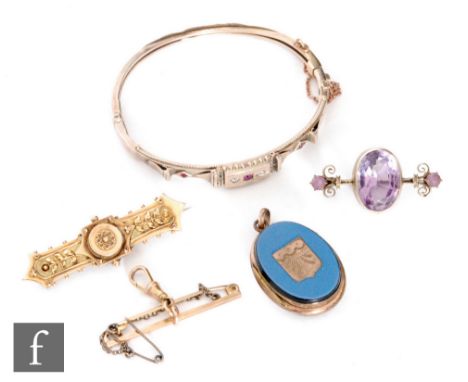 A small parcel lot of jewellery to include a 9ct bangle and two 9ct brooches, total weight 15.5g, with a gilt metal locket an