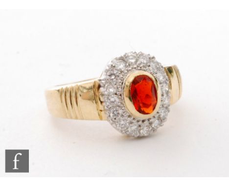 An 18ct hallmarked fire opal and diamond cluster ring, central oval collar set fire opal within a sixteen stone diamond borde