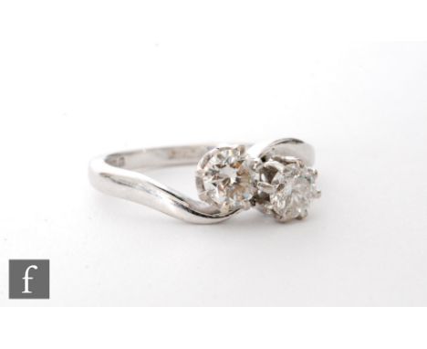 An 18ct white gold hallmarked diamond two stone cross over ring, brilliant cut claw set stones total weight approximately 0.8