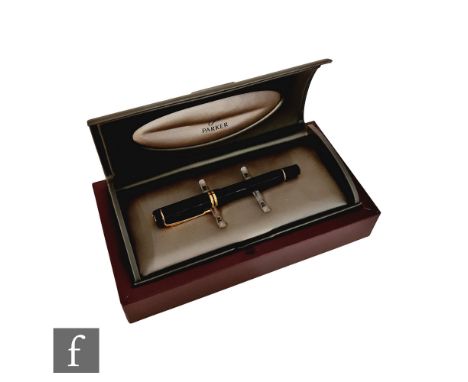 A boxed Parker Duofold roller ball pen in black with 23k gold plated trim. 