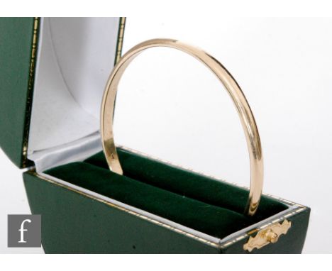 A modern 9ct hallmarked solid single jingle bangle, internal diameter 60mm, width 4mm, weight 19.5g, boxed. 