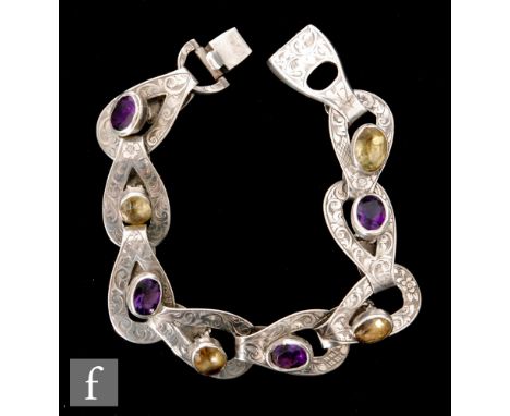 A Victorian white metal Scottish silver bracelet, each of the eight pierced teardrop interlocking links applied with amethyst