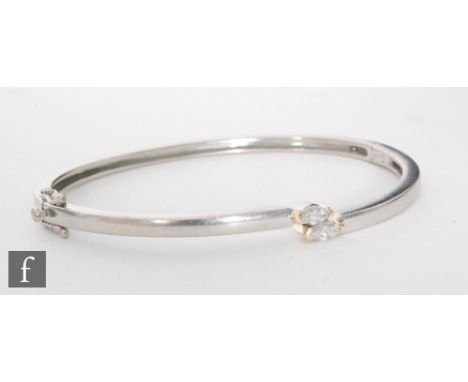 An 18ct white gold hinged bangle set with two marquise cut diamonds each approximately 0.33ct, internal diameter 6cm, weight 