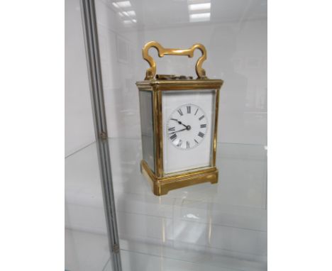 A late 19th/ early 20th Century brass carriage clock, with black Roman numerated dial and original silvered platform with Swi
