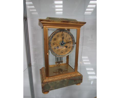 A 19th Century French gilt brass and onyx four glass mantel clock, the gilded Arabic dial with champleve enamel decoration; t