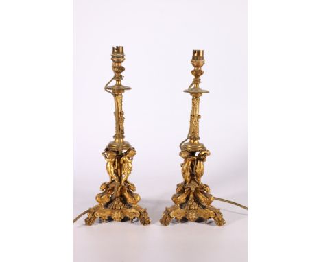 Pair of gilded metal candlestick table lamps, the ornate stems supported by a trio of cherub musicians playing instruments, 4