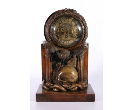 An unusual carved mahogany death clock, the brass dial with gravestone supported by eagle, skull and snake, the reverse inlai