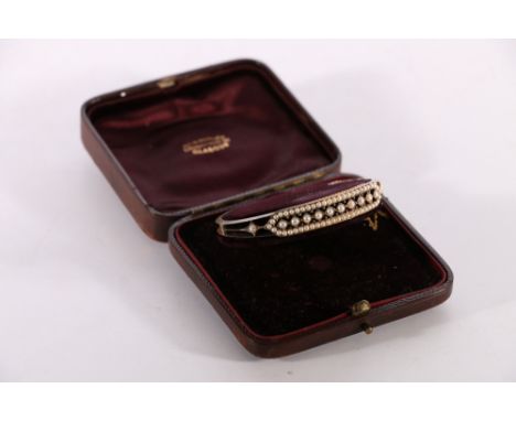 Victorian unhallmarked yellow metal bangle set with seed pearls, 16.2g gross in Sorley of Glasgow fitted box. Bangle discolou