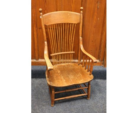 Antique oak comb back armchair with saddled seat raised on turned supports 