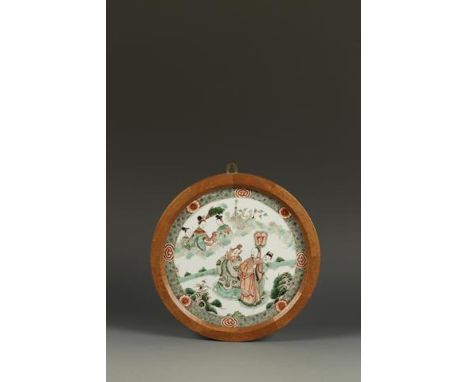 A CHINESE FAMILLE VERTE 'NARRATIVE' ROUNDEL showing an official with two attendants beneath a heavenly scene with three femal