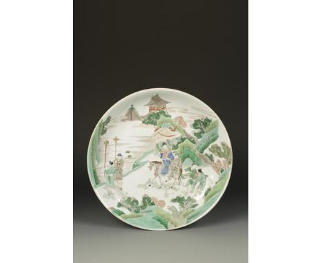 A CHINESE FAMILLE VERTE 'NARRATIVE' CHARGER showing a dignitary on horseback with attendants on a rocky outcrop, Kangxi, 13.5