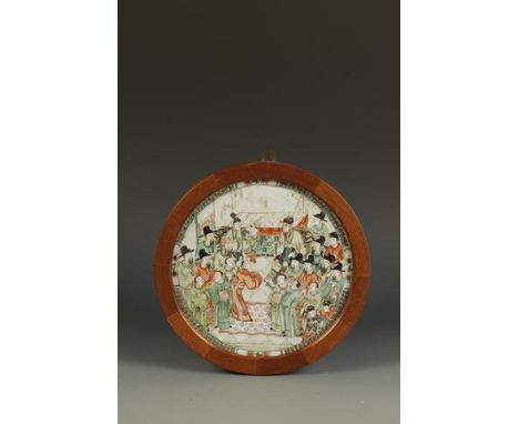 A CHINESE FAMILLE VERTE 'NARRATIVE' ROUNDEL showing numerous figures on opposing sides of an interior, Kangxi, 8.75" (22.2cm)