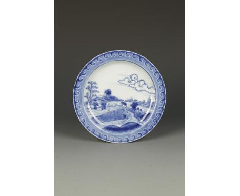 A CHINESE BLUE AND WHITE 'VAN FRYTOM' STYLE PLATE decorated with a Dutch landscape scene within a scroll border, 18th century