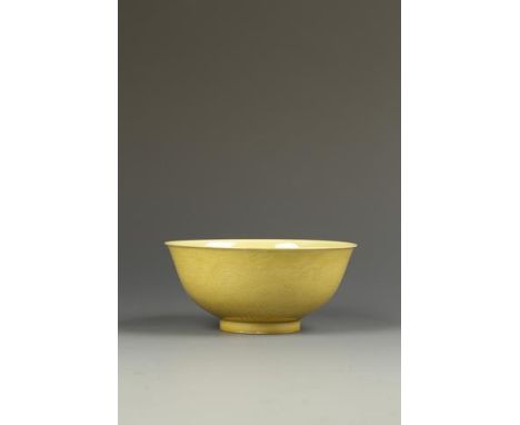 A CHINESE YELLOW-GLAZED 'DRAGON' BOWL, the thin glaze of egg-yolk tone, the exterior incised with two dragons chasing flaming