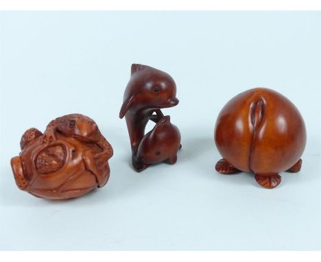 A group of three carved wooden netsuke, comprising a peach, two fish and a toad on a vegetable (3)