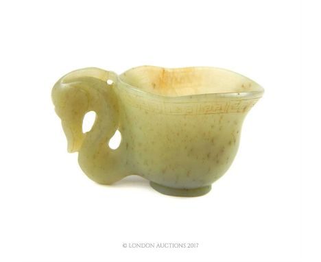 A Chinese carved jade libation cup, having a key pattern below the rim and a serpentine animal head handle, 4.5 x 7 x 4cm.