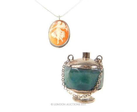 A silver mounted oval shell cameo pendant/brooch carved with a bacchante playing the lyre, 2.6 x 2 cm on a silver chain 46 cm