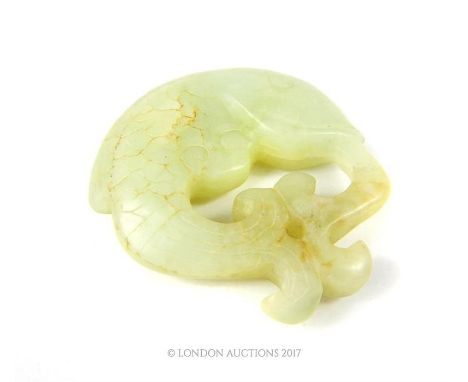 A Chinese carved jade pendant in the form of a fish squirting water from its mouth onto its tail, 5 x 5 x 1cm.