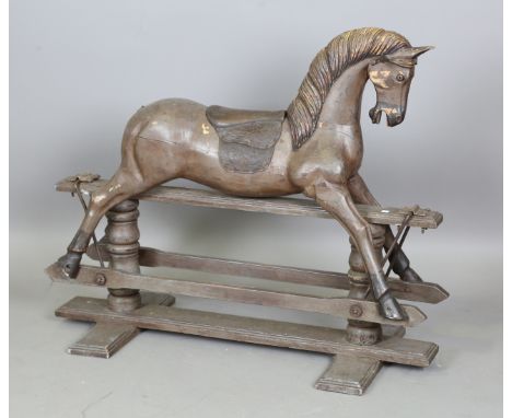 A late 20th century carved and painted wooden rocking horse with carved mane and embossed leather saddle, on a swing frame ba