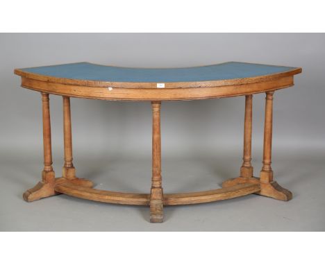 A mid-20th century oak council chambers curved table, the top inset with tooled blue leather, height 77cm, width 162cm, depth