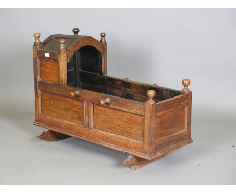 An 18th century rocking cradle of panelled form, the hood with inscribed initials, height 70cm, length 95cm, depth 55cm (faul