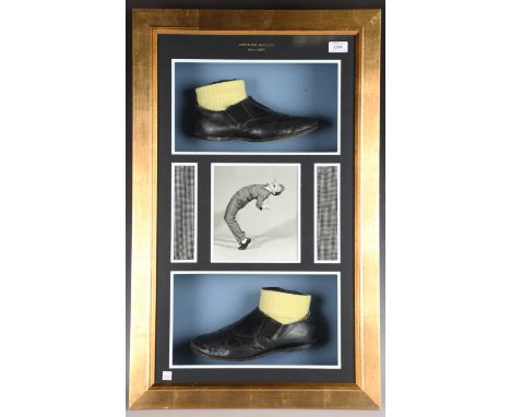 A pair of Norman Wisdom black leather stage shoes, mounted within a glazed display case containing a photograph and two secti