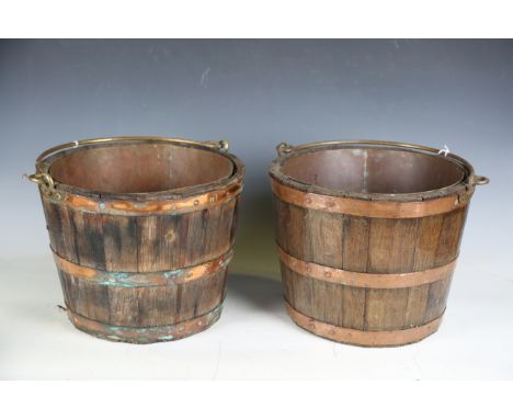 A pair of coopered oak and copper banded buckets with swing-over handles, height 26cm, diameter 34cm.Buyer’s Premium 29.4% (i
