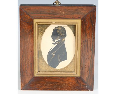 A 19th century silhouette profile portrait of a gentleman with gilt highlights, mounted within a gilt metal surround and rose