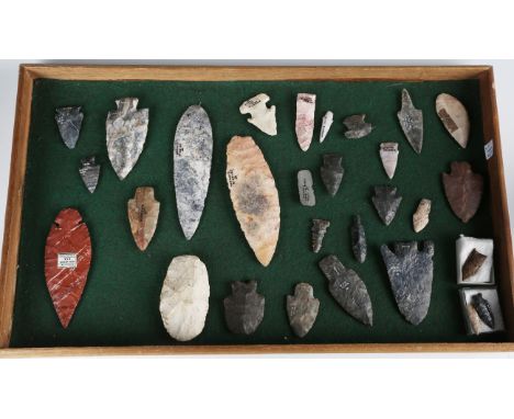 A selection of Native American chip carved stone arrow heads and other implements, one bearing 'F.S. Clark Collection' label,