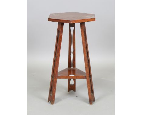 A George V Arts and Crafts style oak hexagonal occasional table, on three fretwork supports united by an undertier, height 68