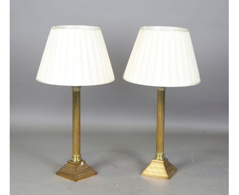 A pair of Edwardian brass Corinthian column table lamps with pleated cream silk shades, height 98cm.Buyer’s Premium 29.4% (in