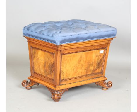 A mid-Victorian walnut box seat ottoman, the hinged seat upholstered in buttoned blue silk, the fall front enclosing shelves,