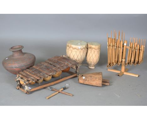 An African gourd xylophone, length 57cm, a pair of earthenware and leather drums, a pottery jar, a bell and a bamboo chime.Bu