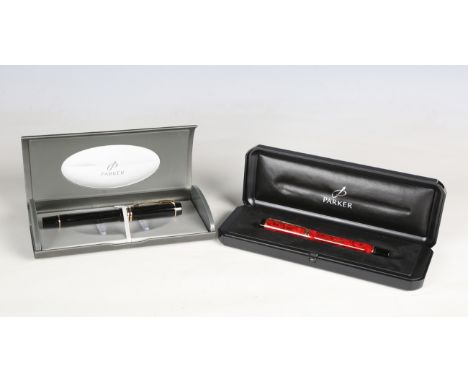 A Parker Duofold fountain pen with black body and a Parker Duofold fountain pen with marbled red body, both cased.Buyer’s Pre
