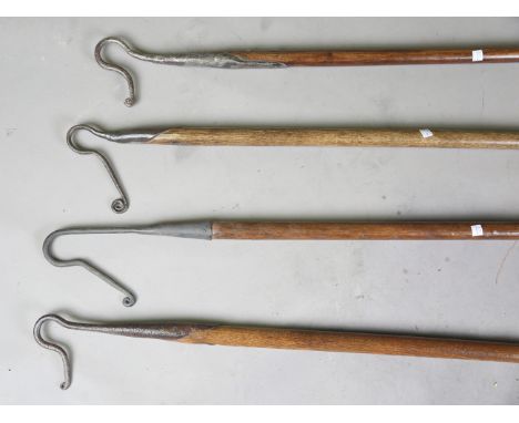 A 19th century wrought iron shepherd's crook with ash shaft, length 141cm, together with three other similar shepherd's crook