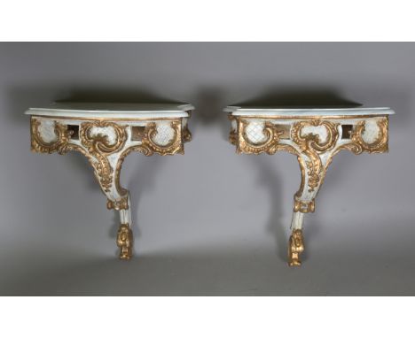 A pair of modern Rococo style white and gilt painted carved wooden console tables with shaped white marble tops, height 61cm,