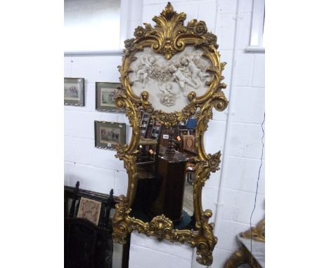 A MODERN GILT FRAMED WALL MIRROR, with separate decorative panel depicting cherubs, approximate size width 70cm x height 152c