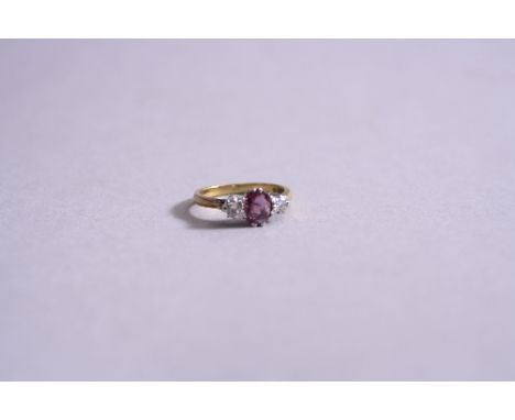 A LATE 20TH CENTURY RUBY AND DIAMOND THREE STONE RING, in 18ct gold, one oval mixed cut ruby measuring approximately 7 x 5 mm