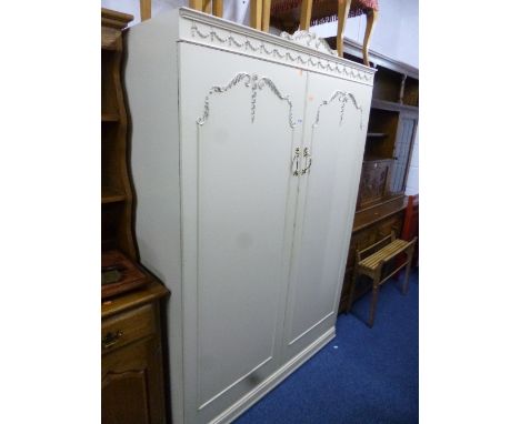 A CREAM AND GILT THREE PIECE BEDROOM SUITE, comprising of a two door wardrobe, dressing table with triple mirror and a chest 