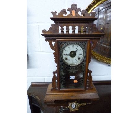 AN AMERICAN MAHOGANY CASED 'GINGERBREAD' MANTLE CLOCK (pendulum and key)