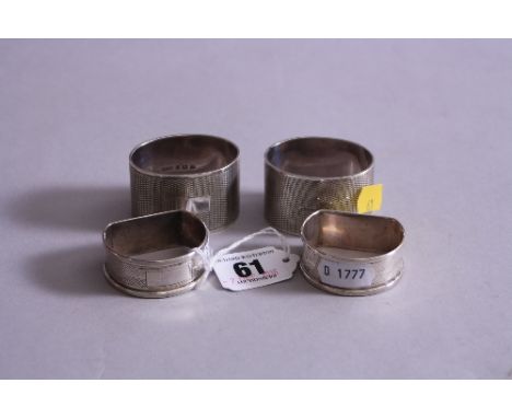 FOUR SILVER NAPKIN RINGS, all with engine turned decoration and vacant cartouches, two oval examples, two demi lune, Birmingh