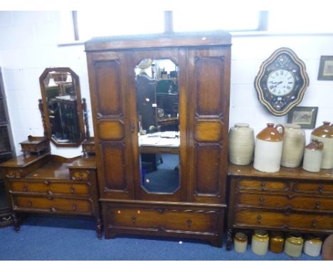 AN OAK THREE PIECE BEDROOM SUITE, comprising mirror door wardrobe with drawer below, dressing table and a three drawer chest